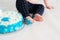 Little kid sitting near white cake, touching it with his hands and trying to taste it. The child has dirty hands and pants from th