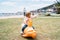 Little kid sitting on a swing in the playground on the beach