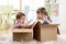 Little kids boy and girl playing in cardboard boxes. Children have fun.