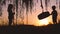 Little kids, boy and girl playing with swing near the lake during beautiful sunset