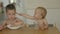 little kids children eating feeding together in kitchen table, loving brother