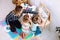 Little kids and educator studying numbers and alphabet on magnetic board sitting on floor in playroom from above view