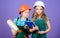 Little kids in helmet with tablet and roller. small girls repairing together in workshop. school project. Labor day. 1