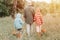 little kids mushroom pickers go to the forest by the hand with their grandmother. family of survivalists gathers a wild fungus har