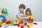 Little kids playing with lots of colorful plastic blocks constructor