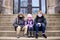 Little Kids Sitting on Steps to School Building with Protective Covid Masks