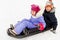 Little kids sliding on sled down hill in winter