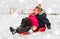 Little kids sliding on sled down hill in winter