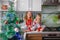 Little laughing twins sit on the table in pajamas in the Christmas decorated kitchen with an Apple. Girl with glasses