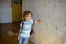 Little learner standing near lockers in school hallway