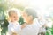 Little  lovely girl and her mother having fun with soap bubbles on blurred nature background. Outdoors at the daytime with bright