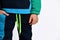 Little male in colorful tracksuit. He has put one hand in pocket, posing isolated on white studio background. Fashion, advertising