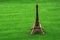 Little model Eiffel Tower on grass