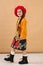 little model girl in designer dress, red hat and military boots full body photo walking