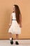 little model girl with long brown hair in designer white dress with belt, military boots full body photo walking.