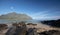 Little Mokolii Island [also known as Chinamans Hat] rocky beach looking toward Kualoa mountains on the North Shore of Oahu Hawaii