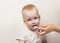 Little mother cleaning her teeth, white background, close up mother