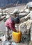 Little Nepalese girl pours water from a water-pump