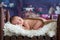 Little newborn baby boy, sleeping in wooden baby bed with little chick