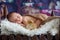 Little newborn baby boy, sleeping in wooden baby bed with little chick