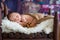 Little newborn baby boy, sleeping in wooden baby bed with little chick