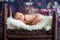 Little newborn baby boy, sleeping in wooden baby bed with little chick