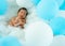Little newborn baby sleep on fluffy of pandas with lot of white and blue balloon