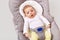 A little newborn girl lies in baby rocking chair, looks around carefully and with interest, exploring the world around her,