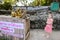 Little nice girl standing near monkey golden statuettes and macaco at zoo in Thailand.