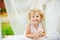 Little old blonde curly girl with wide smile. Happy childhood. Outdoor closeup portrait of small beautiful red haired girl. Child