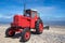 Little old red diesel tractor on the beach.