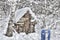 Little old wooden hut in winter forest at heavy snowfall