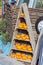 Little orange pumpkins on a wooden triangular rack at a harvest festival. holiday Halloween vertical