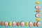 Little orange and yellow Easter eggs arranged alternately in a line with Easter candies designed as egg white with yolk