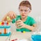 Little pensive boy in safety goggles doing chemical experiments in laboratory