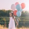 Little pensive girl with colorful balloons