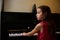 Little pianist musician girl playing piano and singing song, creating music, performing and composing melody on the