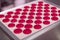 Little pieces of sweet pink mousse lying on baking pan