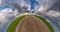 Little planet revolves on road among fields with beautiful blue sky with storm clouds. tiny planet transformation with curvature o