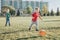 Little preschool boys friends playing soccer football on playground grass field outside. Happy authentic candid childhood