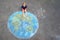 Little preschool girl with earth globe painting with colorful chalks on ground. Positive toddler child. Happy earth day concept.