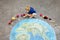 Little preschool girl with flowers and earth globe painting with colorful chalks on ground. Positive toddler child