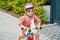 Little preschool girl with helmet running with balance bike on summer day. Happy child driving, biking with bicycle