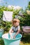 Little preschool girl helps with laundry. Child washes clothes in garden