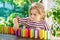 Little preschool girl playing board game with colorful bricks domino. Happy child build tower of wooden blocks