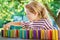 Little preschool girl playing board game with colorful bricks domino. Happy child build tower of wooden blocks