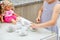 Little preschool girl playing with dolls. Happy excited child play tea party with toys. Role games for children