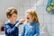 Little preschool girl and preteen school boy brushing teeth. Brother teaching sister brush teeth. Happy siblings. Two