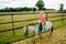 Little preschool girl riding a pony on a farm. Happy lovely child practicing horseback riding. Outdoor summer activities