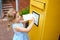 Little preschool girl throwing letter in a mailbox. Excited child writing card or letter for grandparents or family. Old